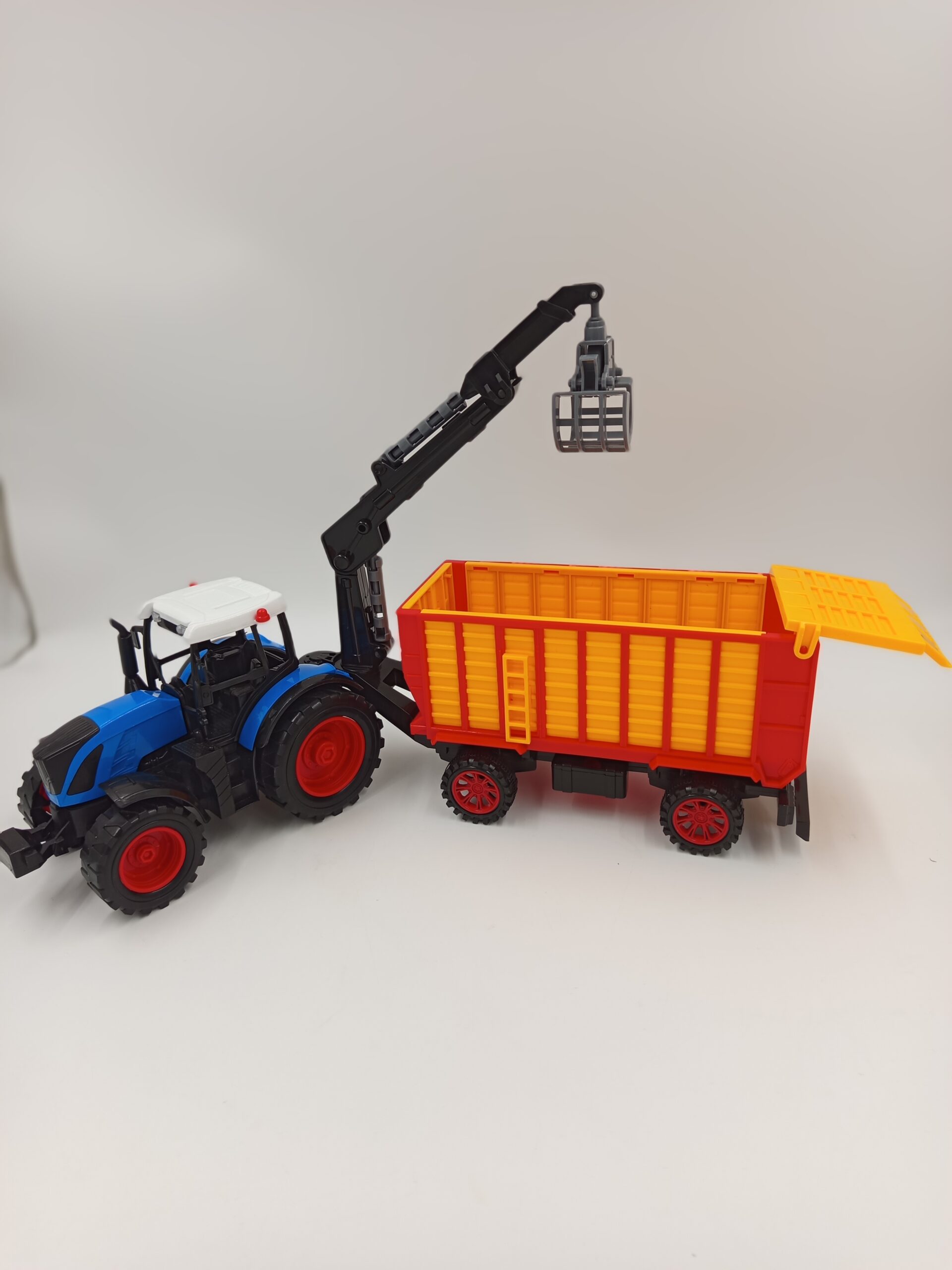 Niebieski traktor z żurawiem i przyczepą kiszonkarską - Raj24