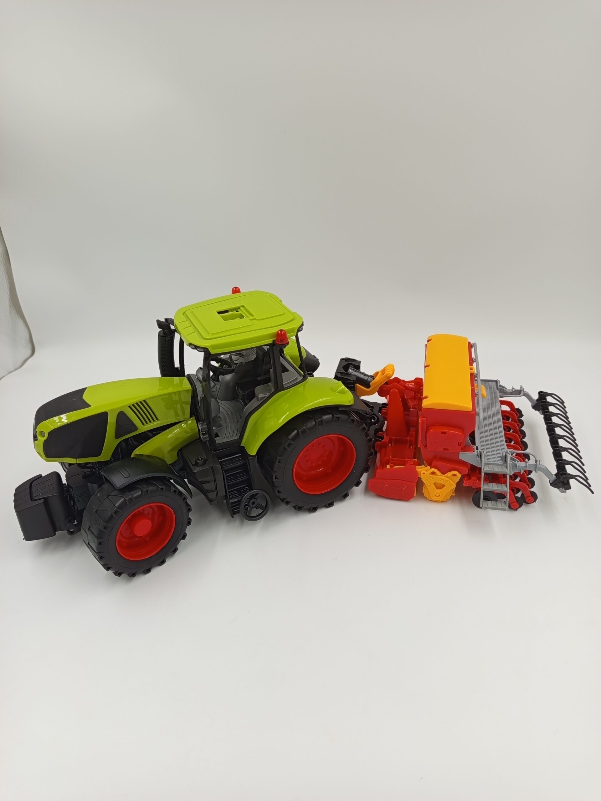 Zielony traktor zabawkowy z siewnikiem do ziarna dla dzieci